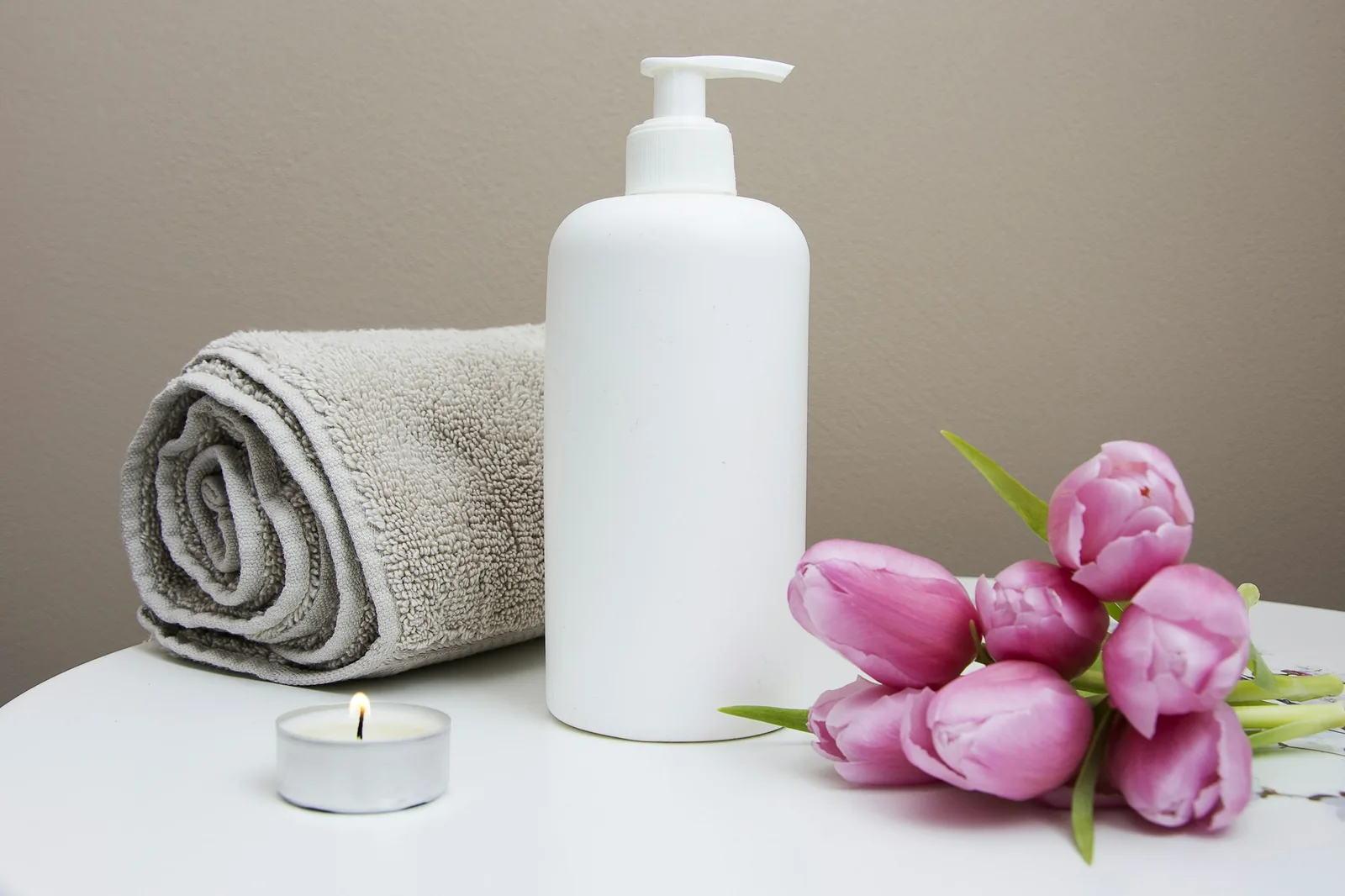 Toallas dobladas, crema y flores frescas